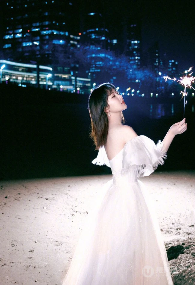杨紫气质V领白裙着身，手拿烟花，夜晚海边浪漫动人写真照