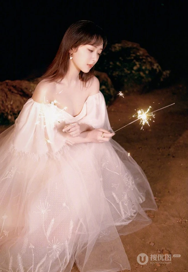 杨紫气质V领白裙着身，手拿烟花，夜晚海边浪漫动人写真照