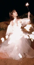 杨紫气质V领白裙着身，手拿烟花，夜晚海边浪漫动人写真照
