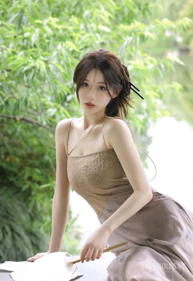 婉约的江南女生着礼裙汉裙手拿小扇湖边凉亭写真图片