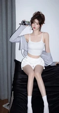 娇俏动人，表情可爱的白色肩带礼裙衣短裤少女手拿相机居家写真照