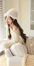 戴着一顶白色绒帽，针织裙，笑容甜美的女生小姐姐居家暖心室内写真图片