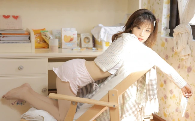 温暖的阳光室内，可爱粉色小短裤居家女生看书，整理好看写真图片