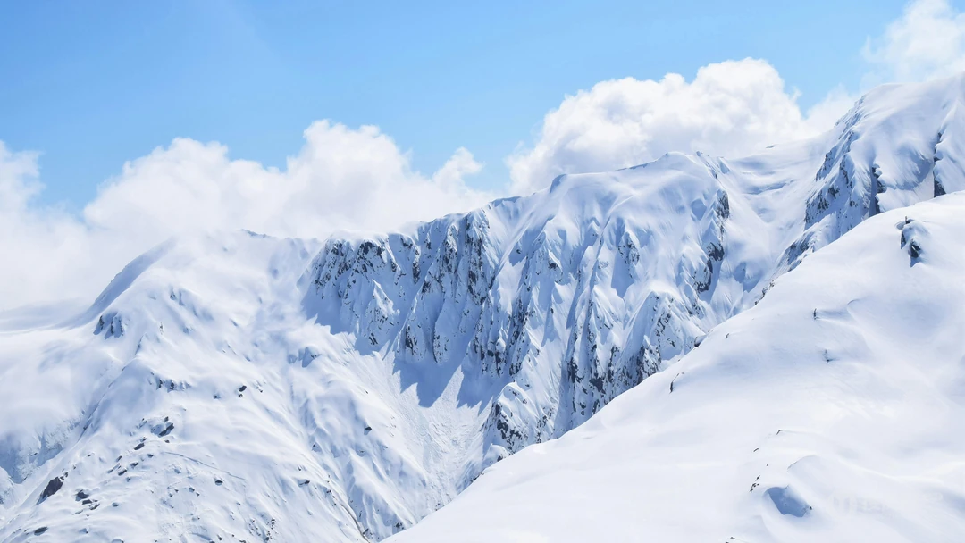 积雪覆盖的山脉，蓝天，白云，雪山上悬崖图片壁纸