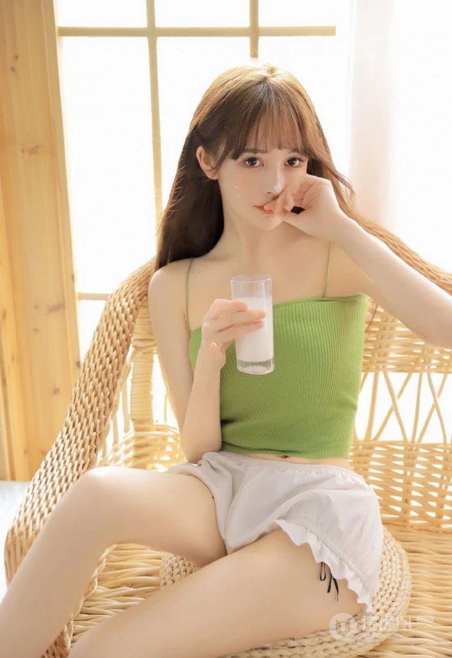 浅粉肌肤气质女生绿色紧身肩带礼裙家居服加白色短裤喝牛奶写真室内照