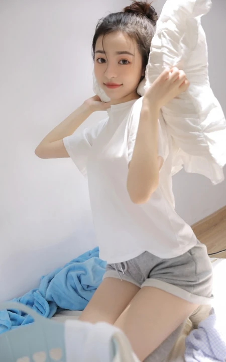 丸子头发型漂亮可人女生身着白色T恤加灰色短裤居家暖房甜美写真照