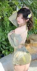 海边绿化树旁正美美摆着poss拍照的超漂亮女生小姐姐镂空裙加泳装美照
