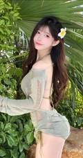 海边绿化树旁正美美摆着poss拍照的超漂亮女生小姐姐镂空裙加泳装美照