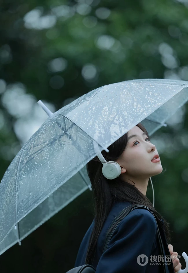轻风细雨，享受一个人的清新和音乐，撑伞行走在阴雨中的女孩漫步绿荫树下摄影美图