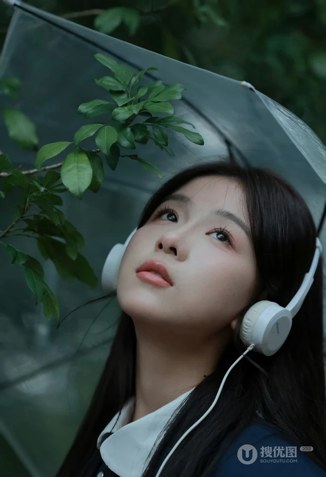 轻风细雨，享受一个人的清新和音乐，撑伞行走在阴雨中的女孩漫步绿荫树下摄影美图