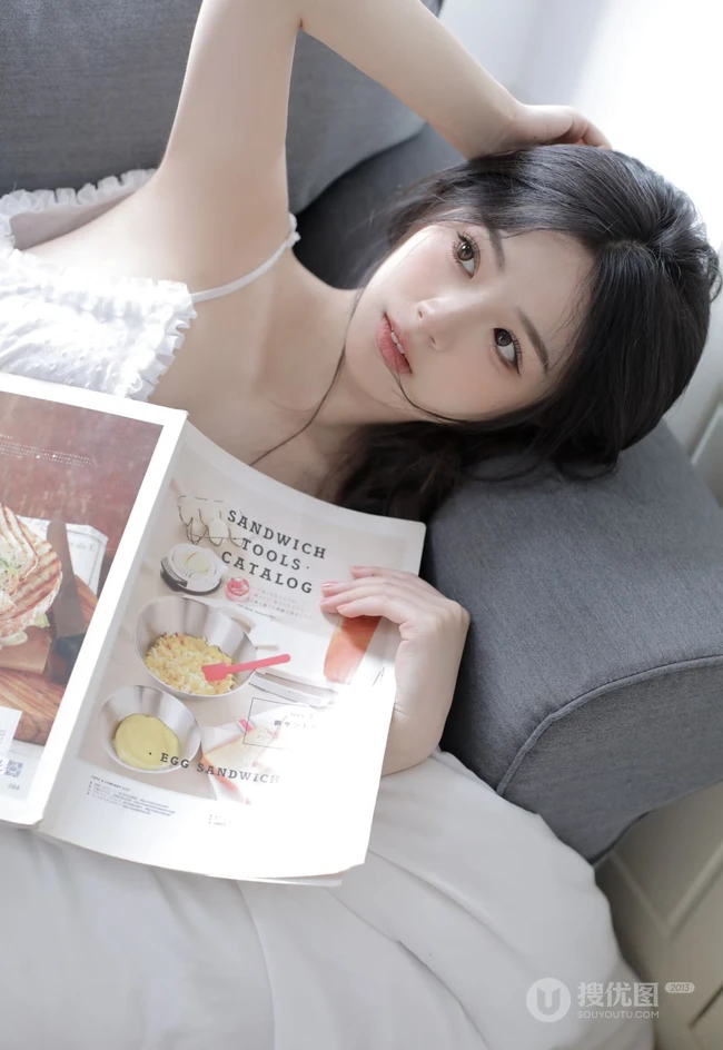 沙发上看画报的甜美可人少女白色肩带居家裙装穿搭高清室内美照