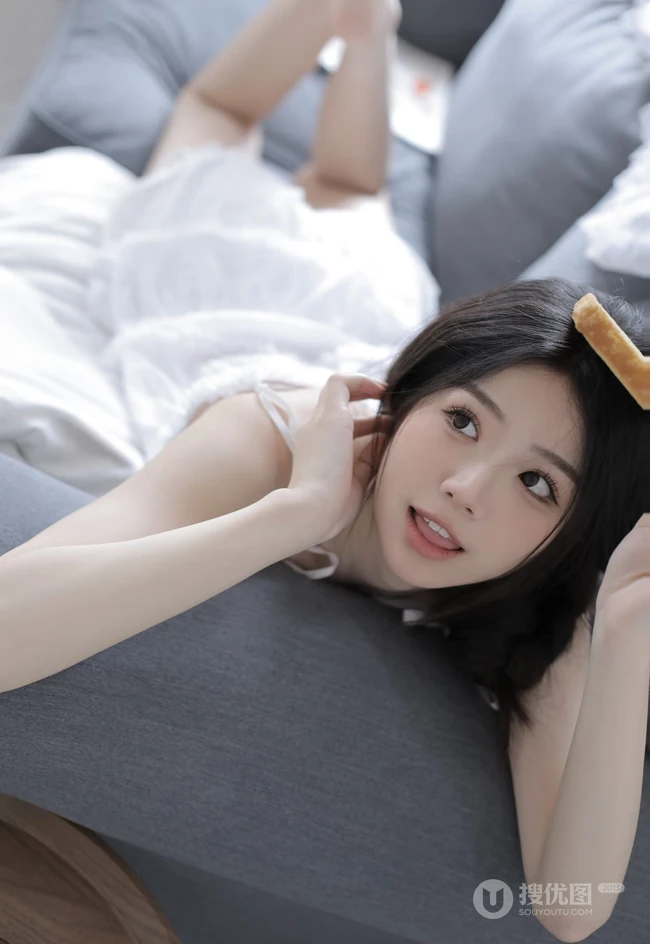 沙发上看画报的甜美可人少女白色肩带居家裙装穿搭高清室内美照