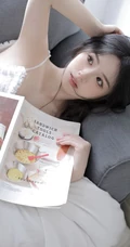 沙发上看画报的甜美可人少女白色肩带居家裙装穿搭高清室内美照