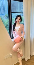 早晨起来做瑜伽球运动的可爱女生粉色紧身连衣衣穿室内自拍美照