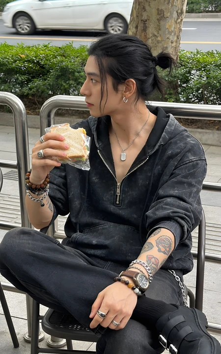 街头扎马尾潮男户外坐着手拿三明治随拍
