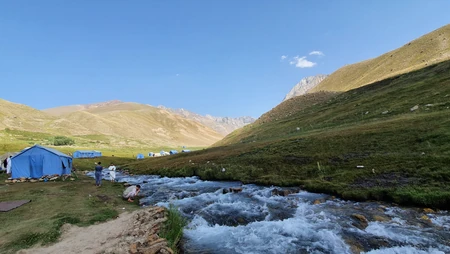 高原山谷溪流边的户外露营自然风光