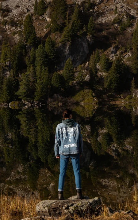 女子站在岩石上眺望山林湖景自然风光