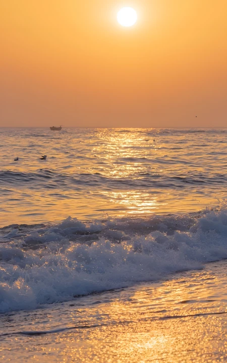 海边落日金色海面翻涌浪漫自然风景