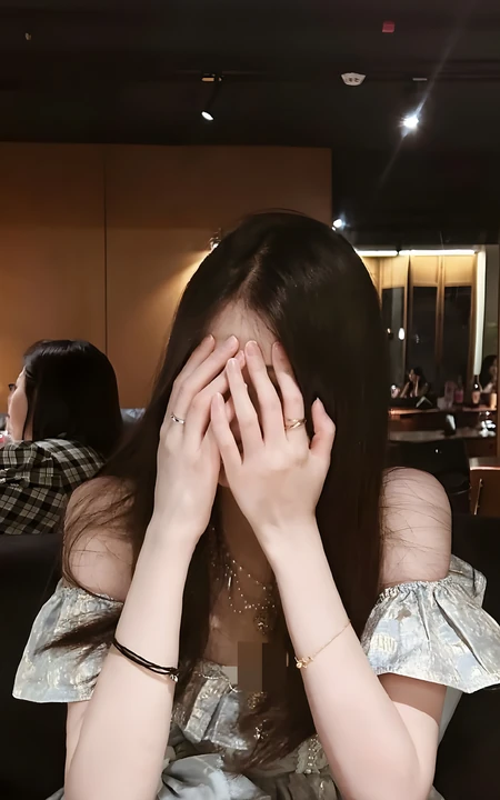 餐厅内双手捂脸的长发气质女生